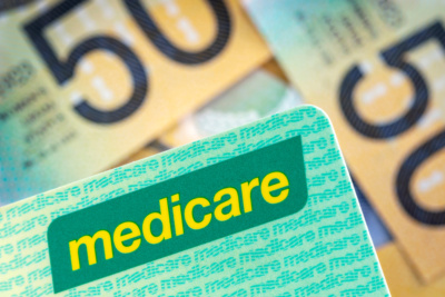 Australian Medicare card over blurred money background.